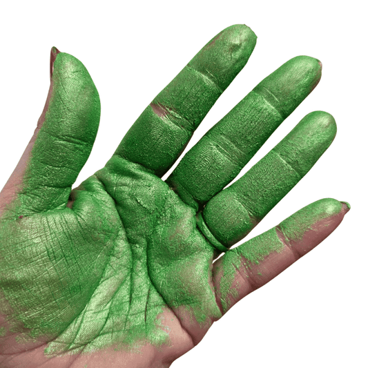 Hand with green mica pigment on a white background