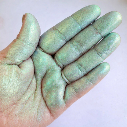 Iridescent chameleon pigment powder on hand showing peppermint green to turquoise colour shift for resin and craft projects