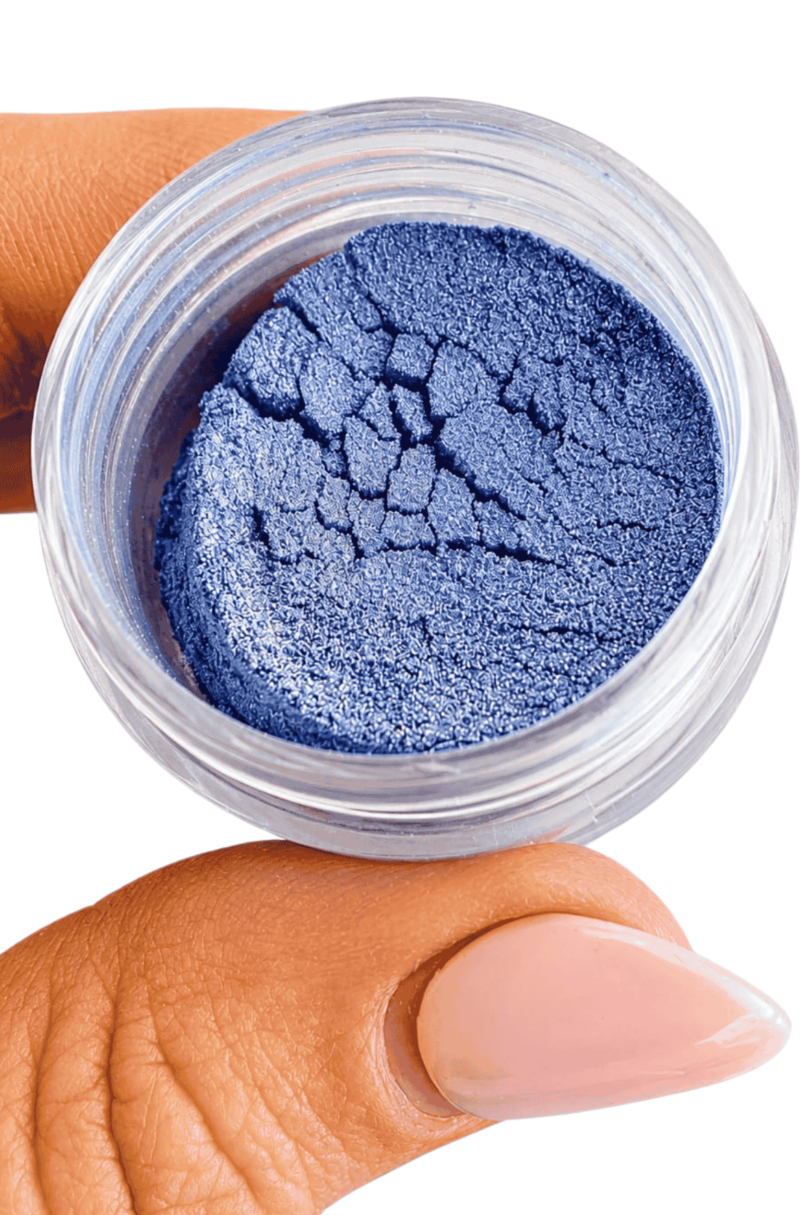 Blue makeup powder in a small open jar held by a hand. Blue lilac, purple, cornflower in colour, 