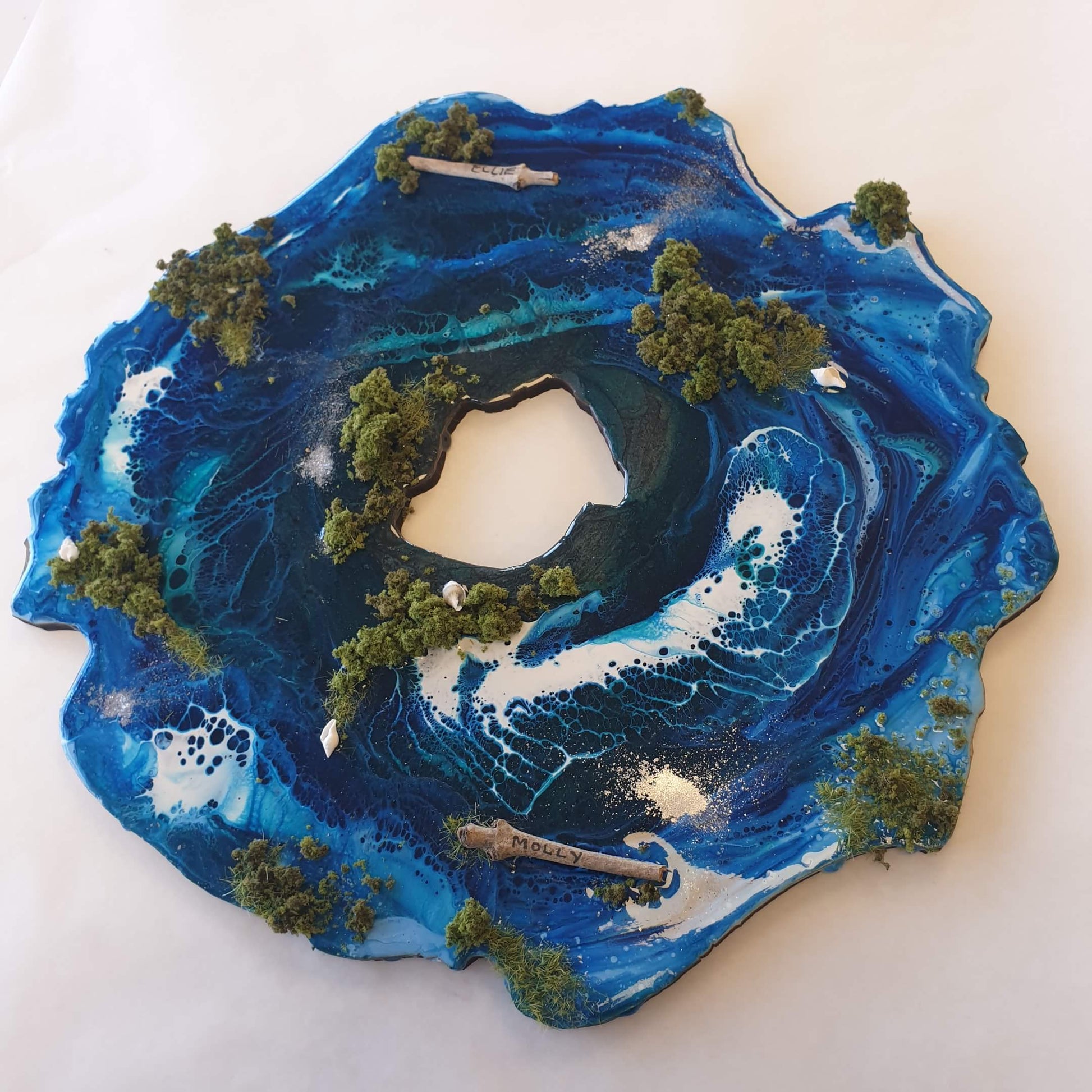 Artistic depiction of a wave with trees and a path on a white background