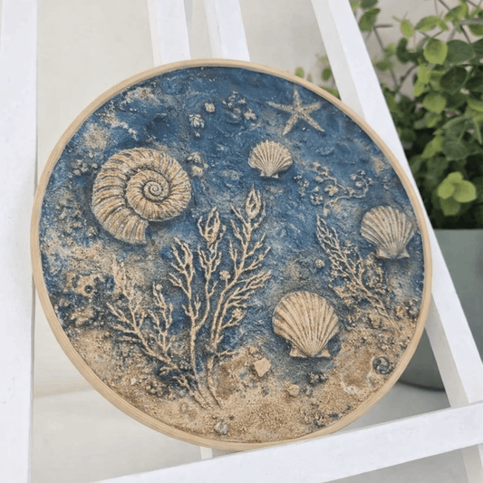 shells and sea textures pressed into clay and eco pour in a round hoop 
