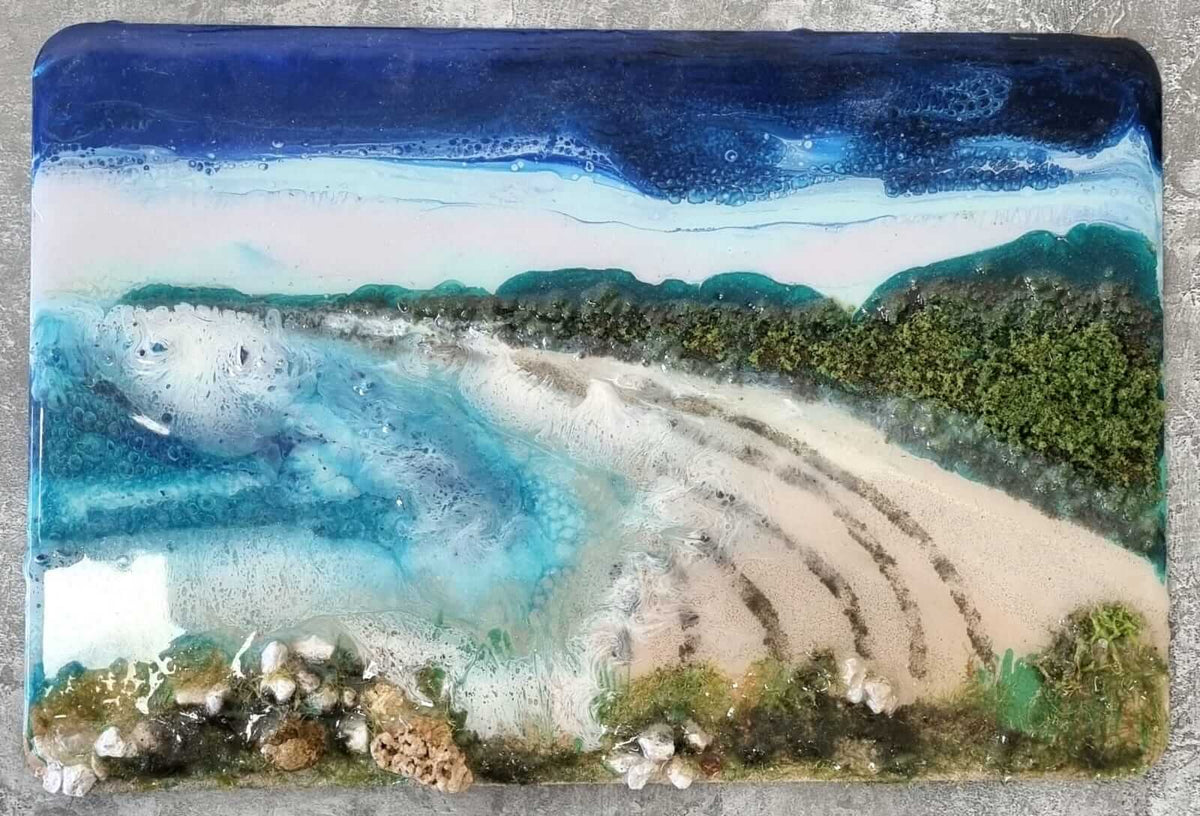Artistic depiction of a coastal scene with mountains and water on a rectangular surface.