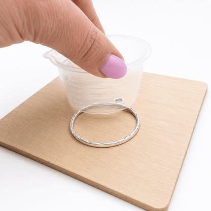 Securing an open-backed jewellery bezel onto resin stop tape